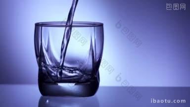 特写的家庭玻璃被装满水从瓶子<strong>倒</strong>在蓝色背景超慢动作p